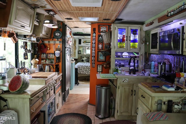 kitchen featuring light tile patterned floors, wooden ceiling, and sink