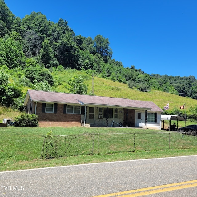 ranch-style house featuring a carport and a front lawn