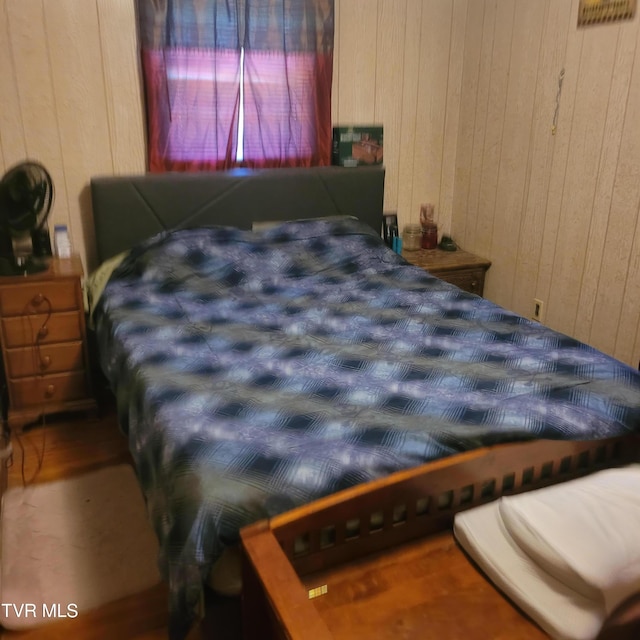 bedroom featuring wooden walls