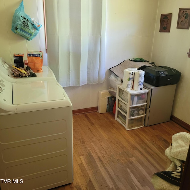 laundry room with washer and clothes dryer and light hardwood / wood-style floors