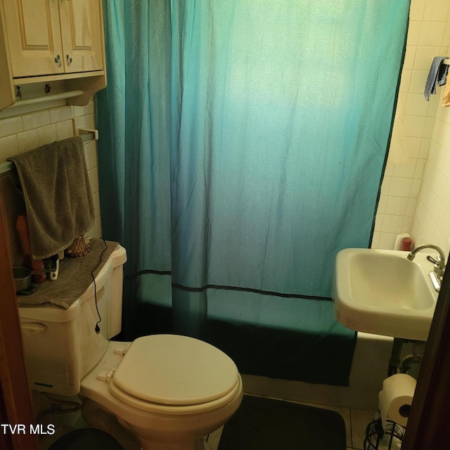 full bathroom with toilet, decorative backsplash, shower / tub combo with curtain, and sink