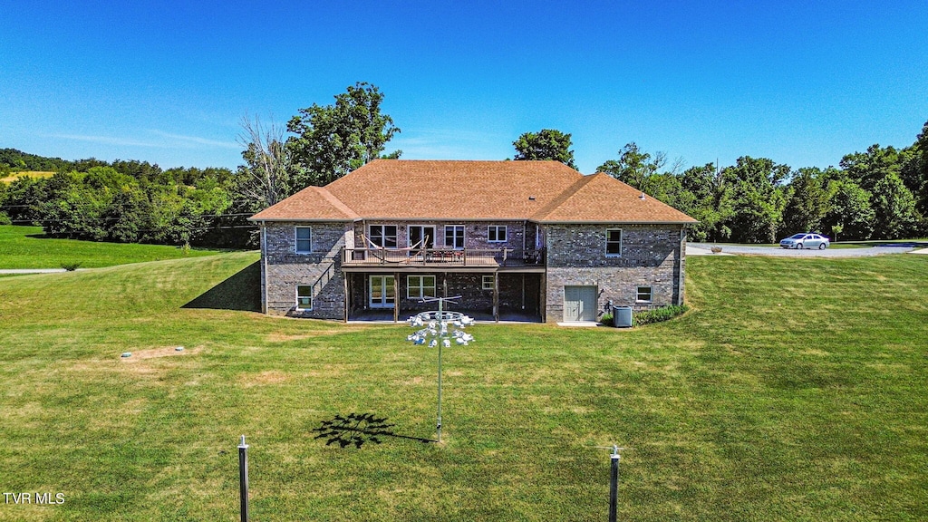 rear view of house with a lawn and a wooden deck