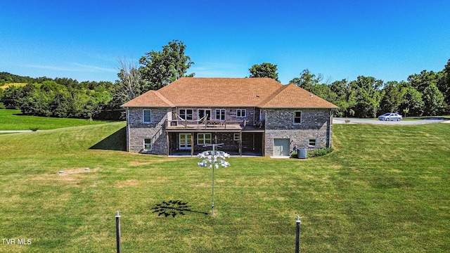 rear view of house with a lawn and a wooden deck