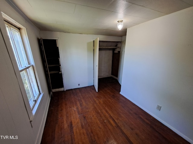 unfurnished bedroom featuring dark hardwood / wood-style floors and a closet