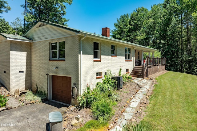 view of front facade with a porch, cooling unit, a garage, and a front yard