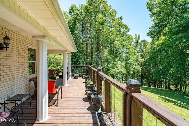 wooden deck featuring a lawn