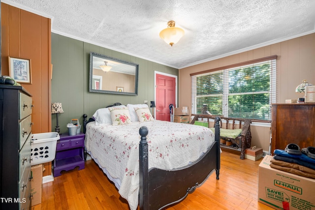 bedroom featuring crown molding, wood-type flooring, and wood walls