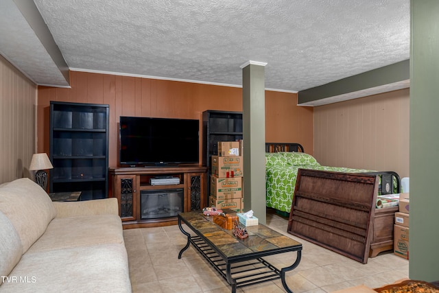 living room featuring a textured ceiling, crown molding, wood walls, a fireplace, and light tile patterned flooring