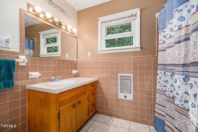 bathroom featuring vanity, heating unit, tile patterned floors, and tile walls