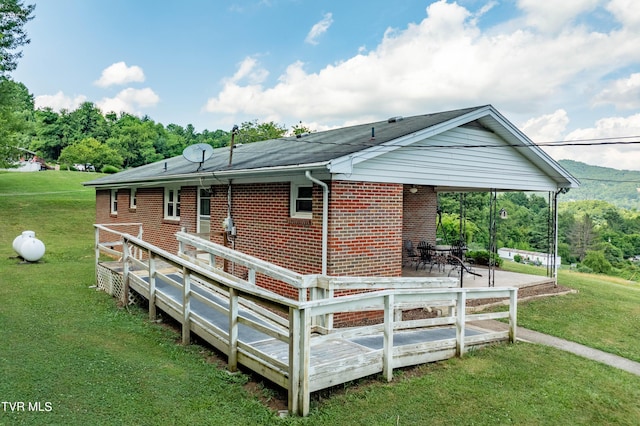 back of house featuring a patio area, a deck, and a lawn