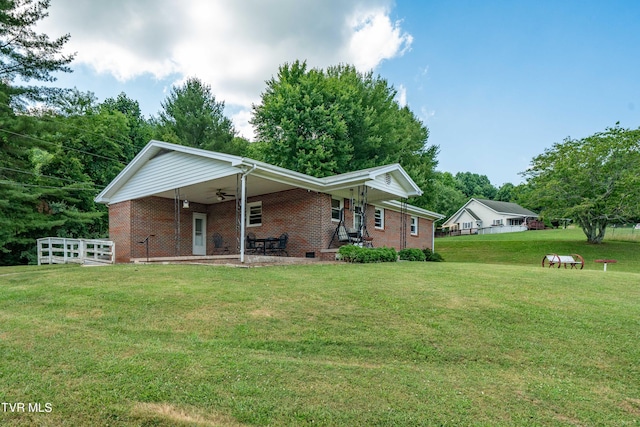 view of front of home featuring ceiling fan and a front yard