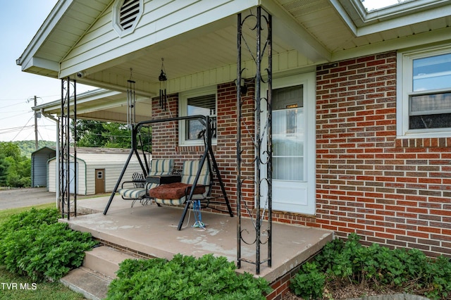 view of patio featuring a storage shed and covered porch