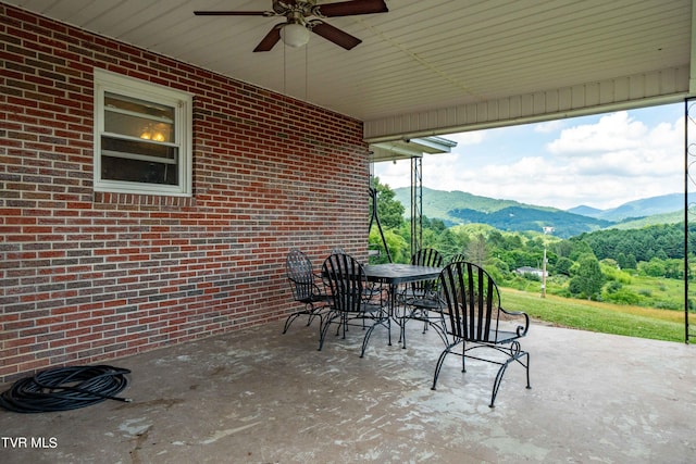 view of patio / terrace with ceiling fan and a mountain view