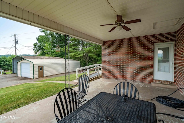 view of patio / terrace with a garage, an outbuilding, and ceiling fan