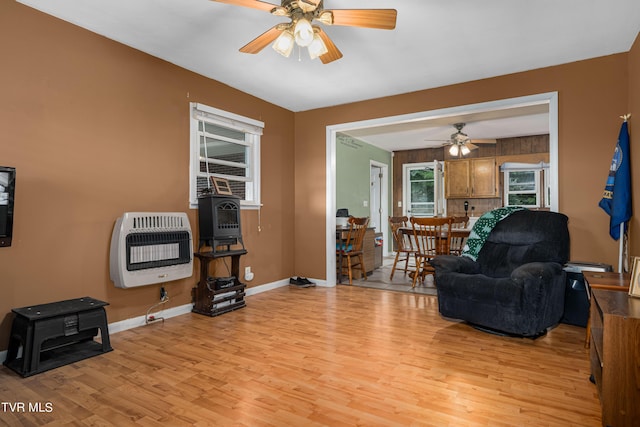 sitting room with light wood-type flooring, ceiling fan, and heating unit