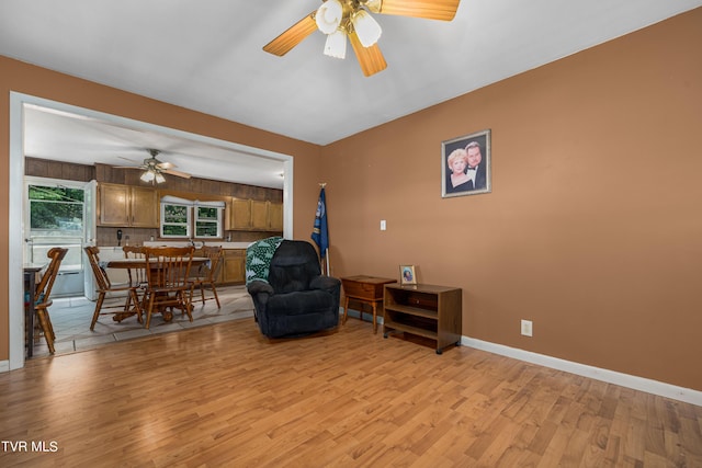 living area with ceiling fan and light hardwood / wood-style floors