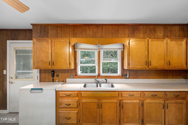 kitchen featuring sink, light tile patterned floors, and wooden walls