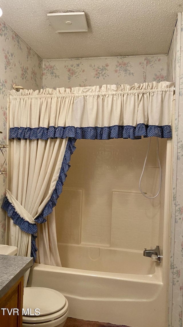 full bathroom with shower / bath combo, toilet, a textured ceiling, and vanity