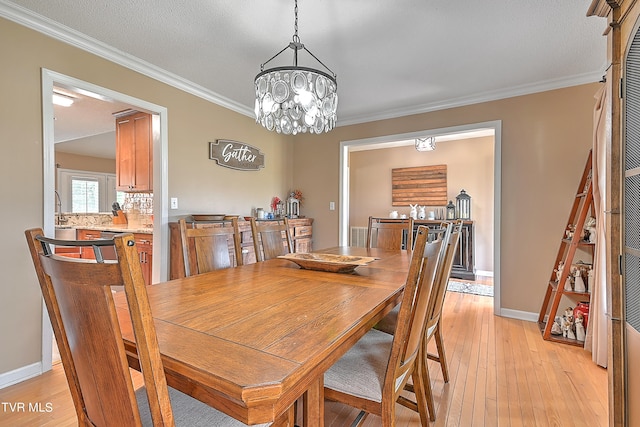 dining room featuring crown molding, a notable chandelier, and light hardwood / wood-style flooring