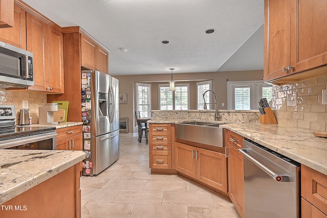 kitchen featuring appliances with stainless steel finishes, tasteful backsplash, decorative light fixtures, and light tile patterned floors