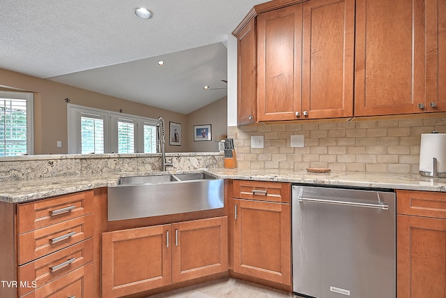 kitchen featuring lofted ceiling, dishwasher, backsplash, light stone counters, and sink