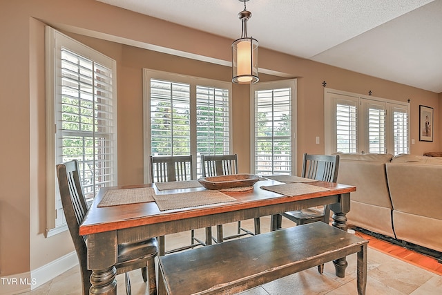 dining space featuring light hardwood / wood-style flooring and a textured ceiling