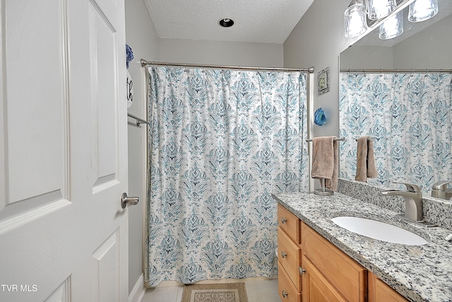 bathroom with vanity, tile patterned floors, and a textured ceiling