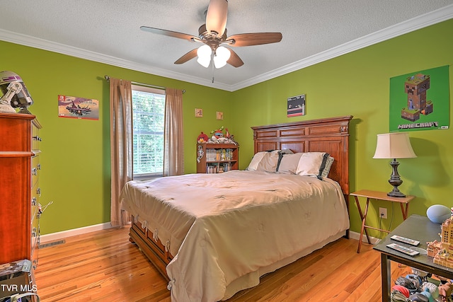 bedroom featuring a textured ceiling, ceiling fan, hardwood / wood-style floors, and crown molding