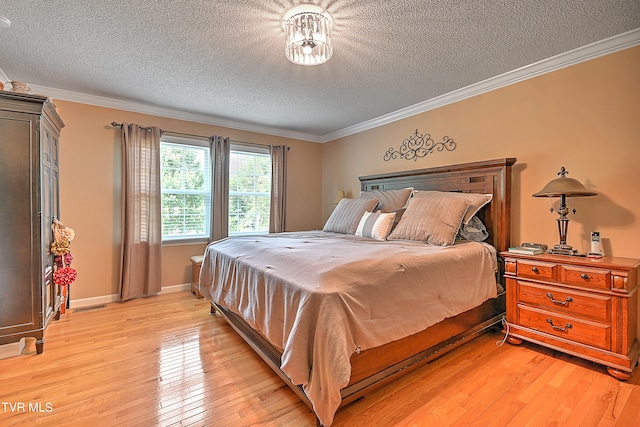 bedroom with crown molding, light wood-type flooring, and a textured ceiling