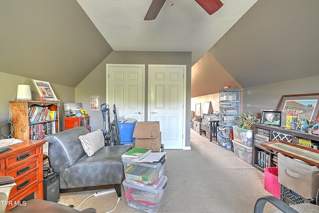 living area featuring carpet floors, a textured ceiling, ceiling fan, and vaulted ceiling