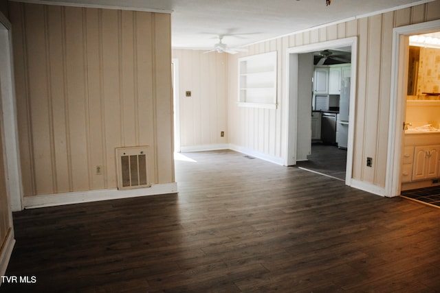 unfurnished room with built in shelves, ceiling fan, sink, dark wood-type flooring, and crown molding