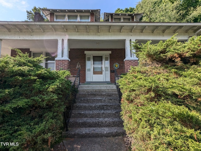 view of exterior entry with a porch