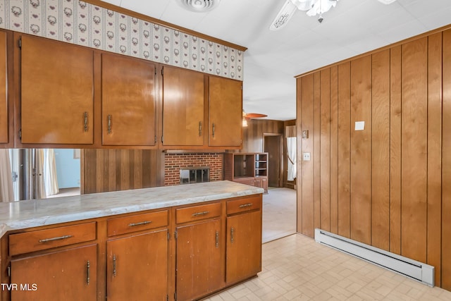 3054 Redbud Hwy, Honaker, VA 24260 - kitchen featuring baseboard heating, a ceiling fan, light countertops, wooden walls, and brown cabinetry