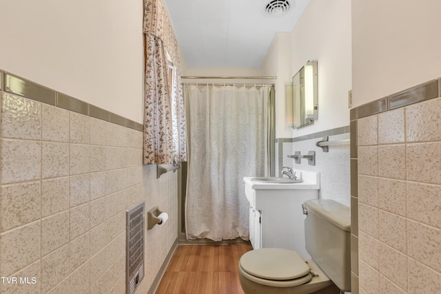 3054 Redbud Hwy, Honaker, VA 24260 - full bathroom with tile walls, wood finished floors, wainscoting, vanity, and heating unit