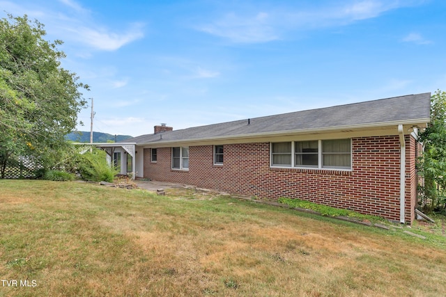 3054 Redbud Hwy, Honaker, VA 24260 - rear view of property with brick siding, a yard, and a chimney