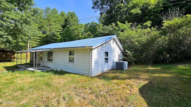 exterior space with cooling unit and a yard