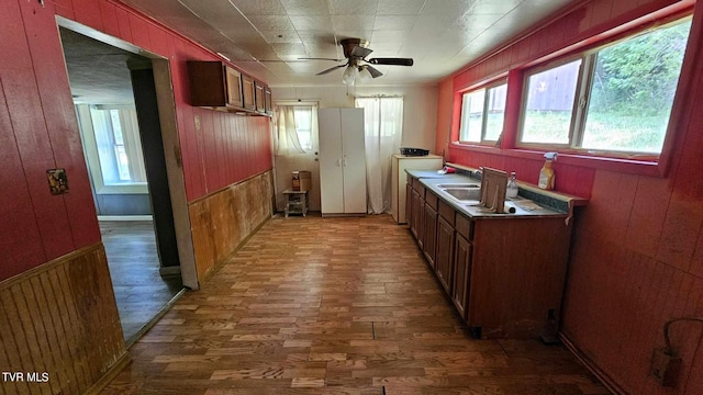 kitchen featuring ceiling fan, dark hardwood / wood-style flooring, and wood walls