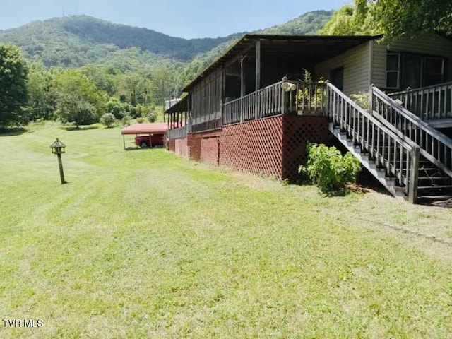 view of side of property with a mountain view and a lawn