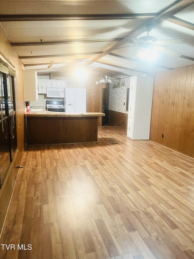 kitchen with kitchen peninsula, white appliances, lofted ceiling with beams, light hardwood / wood-style flooring, and white cabinetry