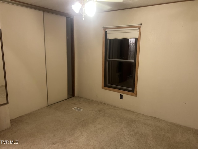 interior space featuring ceiling fan, a closet, and light colored carpet