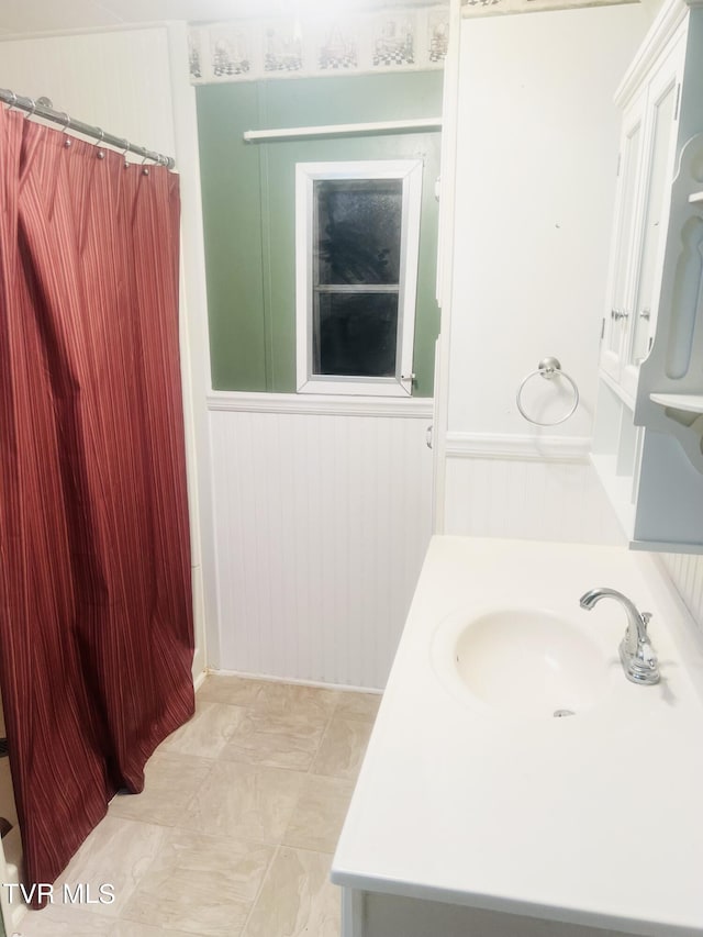 bathroom with vanity and wood walls