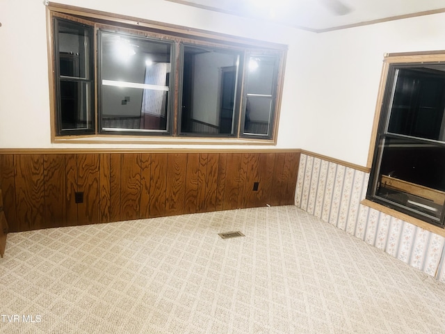 unfurnished room with light carpet and wooden walls