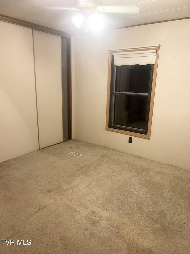 unfurnished bedroom with carpet flooring, a closet, and ceiling fan