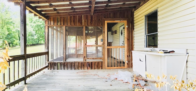 unfurnished sunroom featuring sink and lofted ceiling with beams