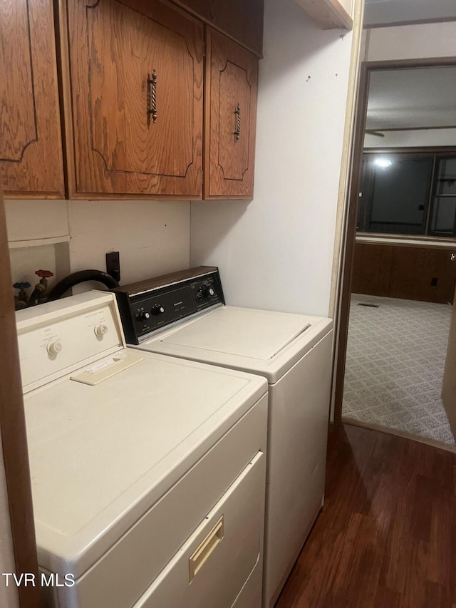 laundry area with cabinets, dark hardwood / wood-style flooring, and washing machine and dryer