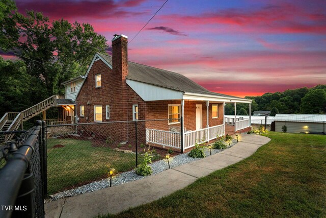 view of front of home featuring a porch and a yard