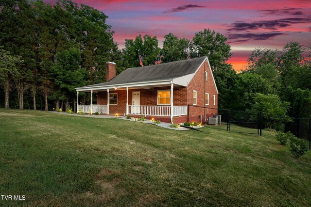 view of front of house featuring covered porch and a lawn