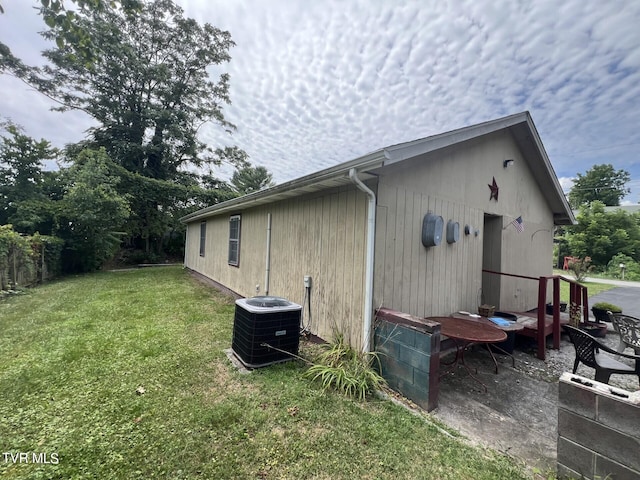 view of home's exterior with central air condition unit and a yard