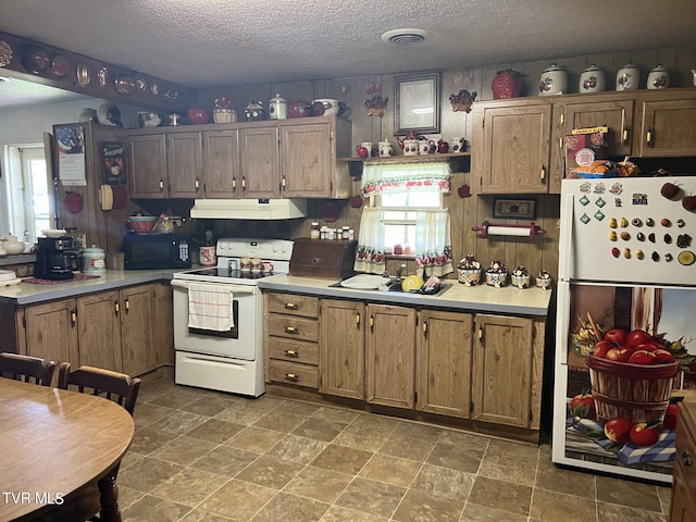 kitchen with tile patterned floors, a textured ceiling, and white appliances