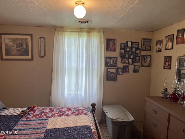 bedroom with multiple windows and a textured ceiling